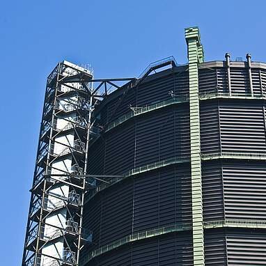 Bild vom Gasometer Oberhausen vor blauem Himmel weil KAMP in Oberhausen ansässig ist.